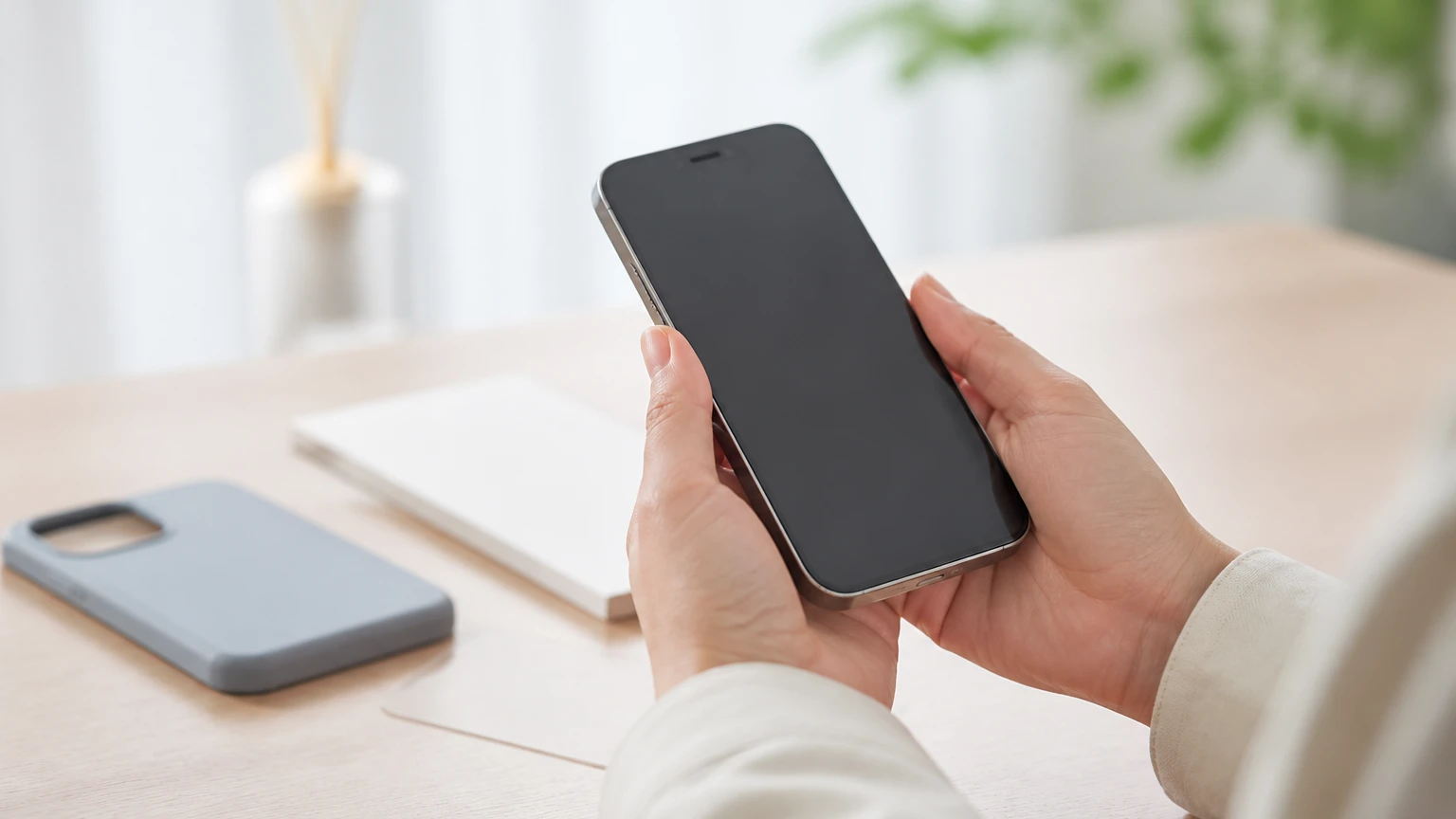 新しいスマートフォンを両手で大切に持つ様子とケース・保護フィルム