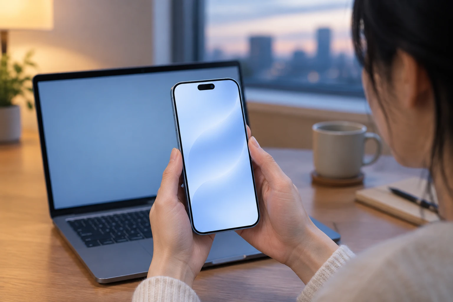 自宅のノートパソコンでオンライン手続きをしながら、新しいiPhoneを設定している様子