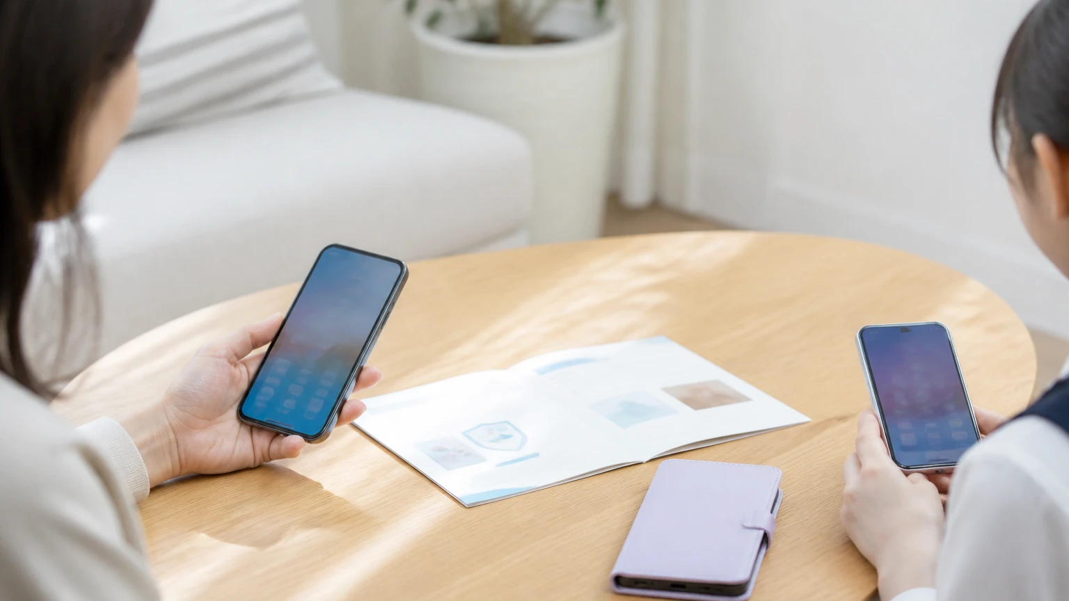テーブルに並んだ2台のスマートフォンと案内のパンフレット